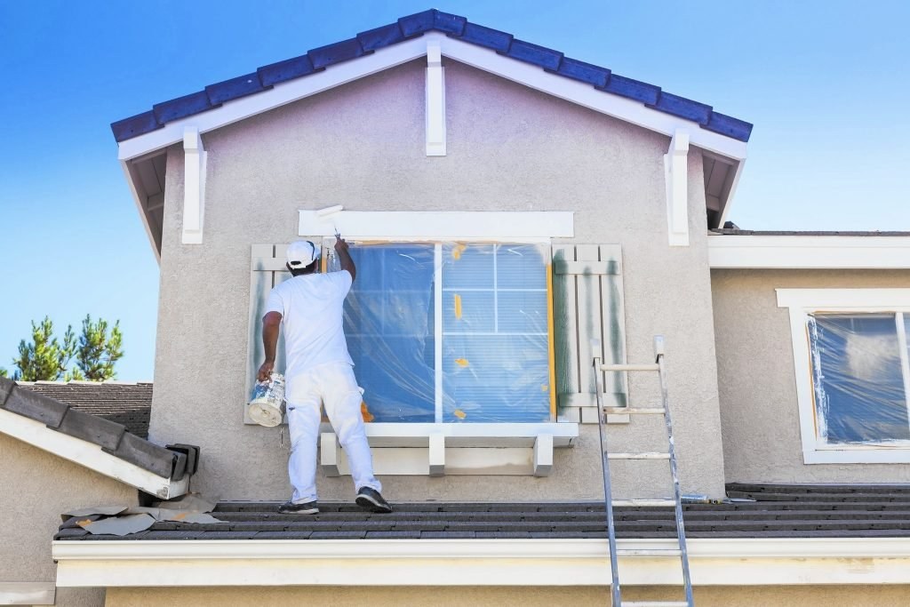 Painter painting the exterior of a house